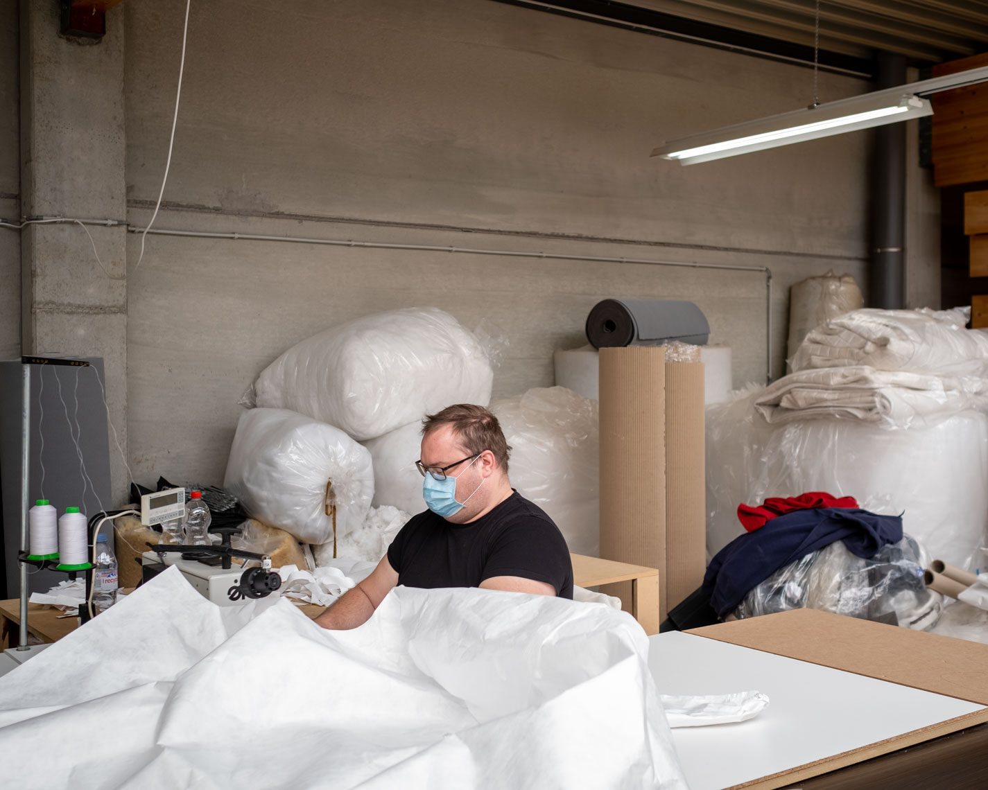Een werknemer maakt beschermende kledij voor de zorgsector in Mechelen